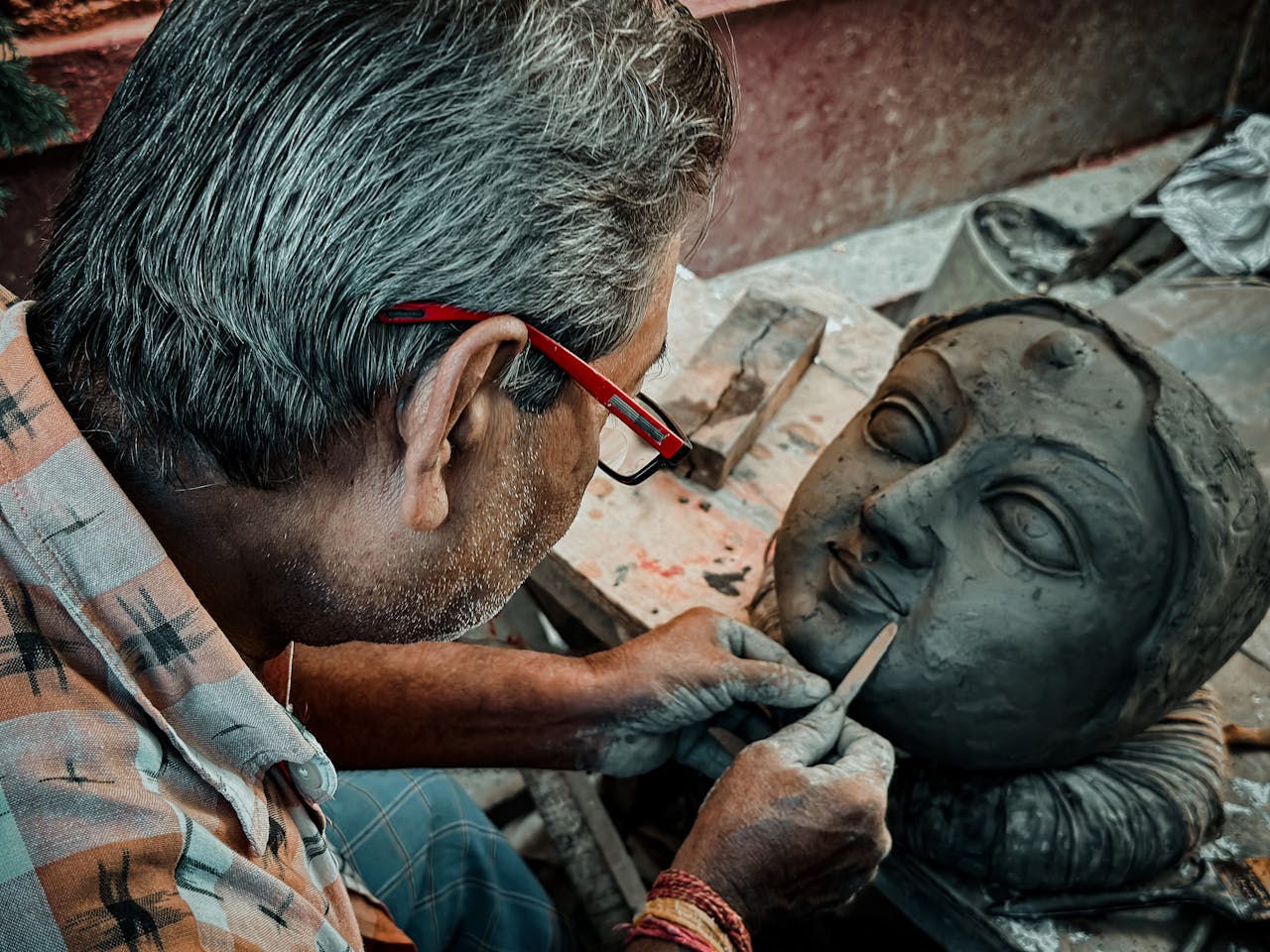 Home An artisan carefully crafts a clay icon of Hindu goddess Durga in Kolkata, India, showcasing traditional artistry.