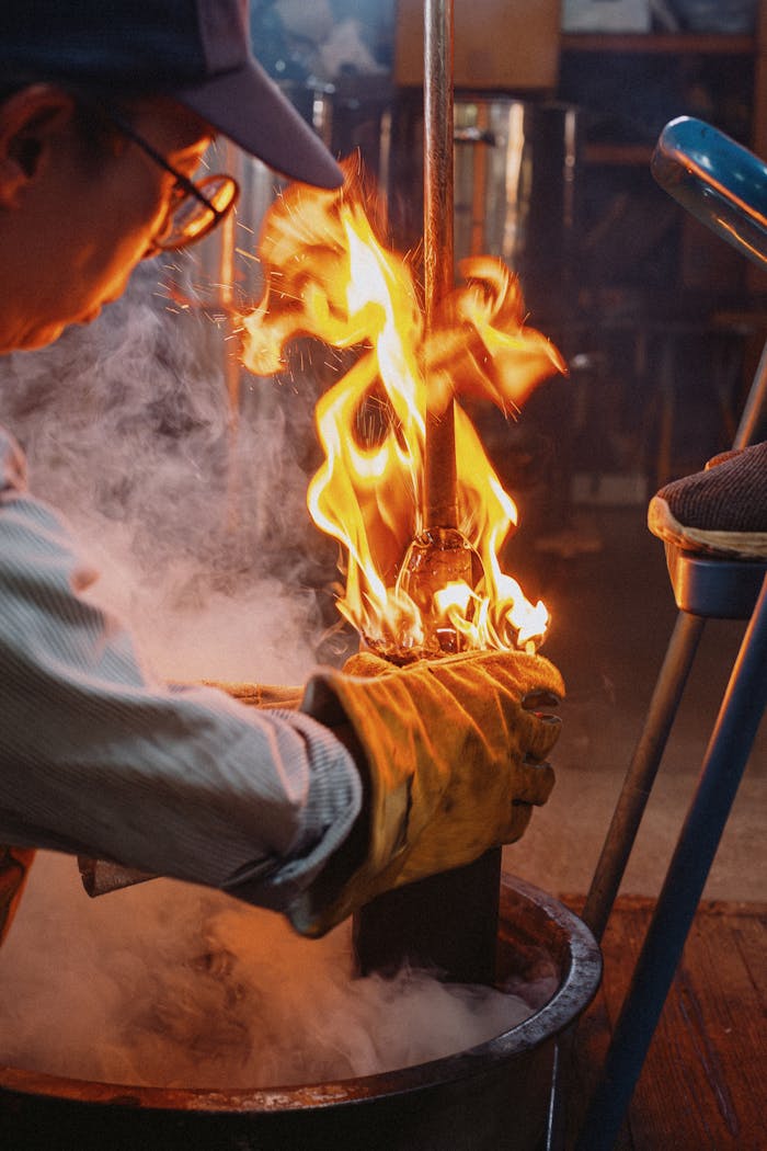 A skilled artisan working with fire in a glass-blowing studio in Nagano, Japan.